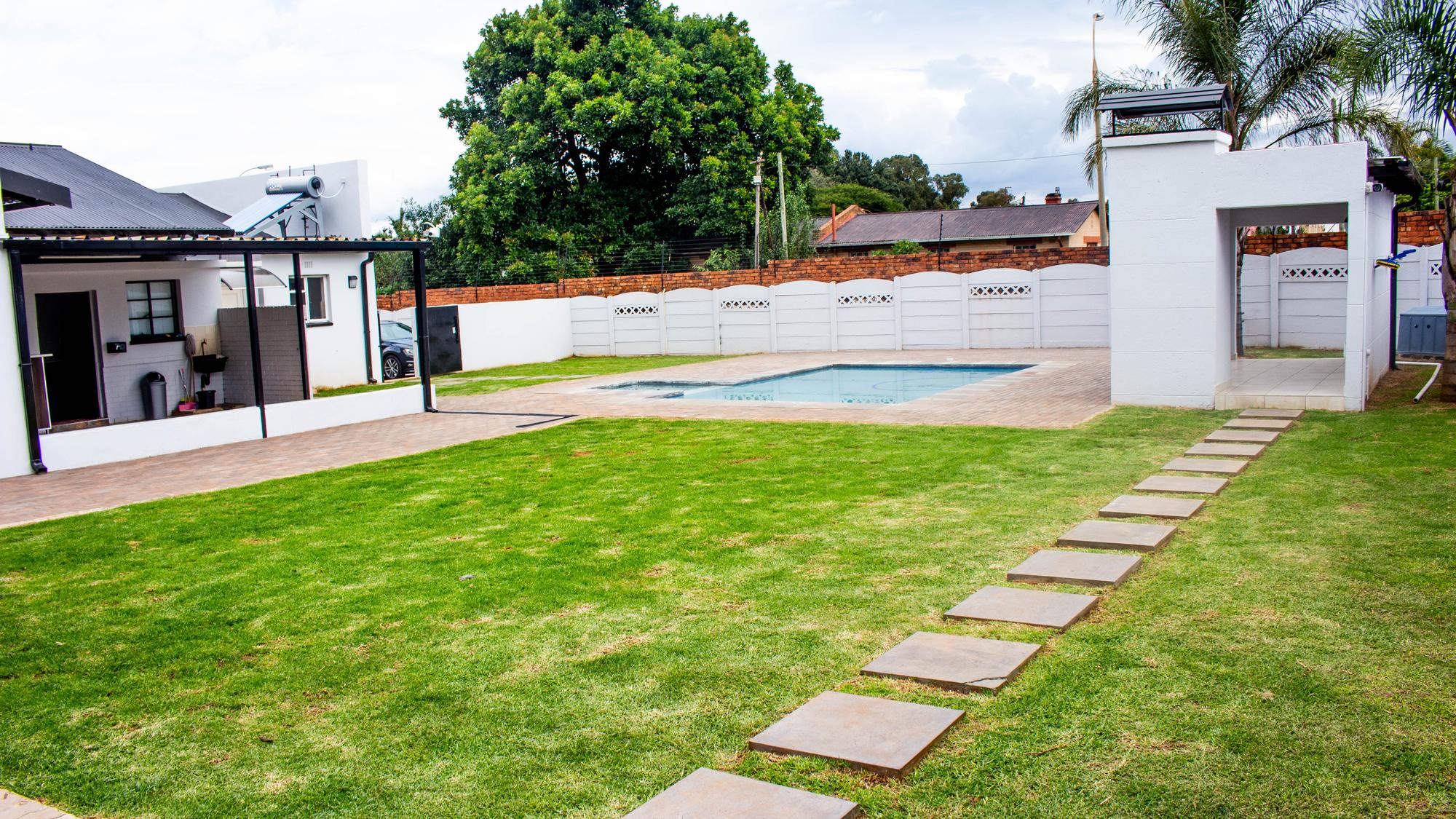 The lawned garden and swimming pool at Phela Guest House in Chloorkop, Edenvale